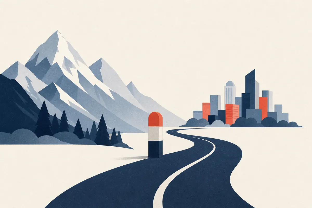 Une route qui franchit une borne frontière entre montagnes et ville